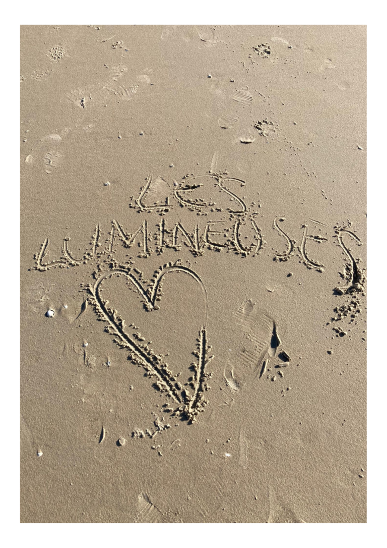 Les lumineuses écrit sur le sable avec un cœur